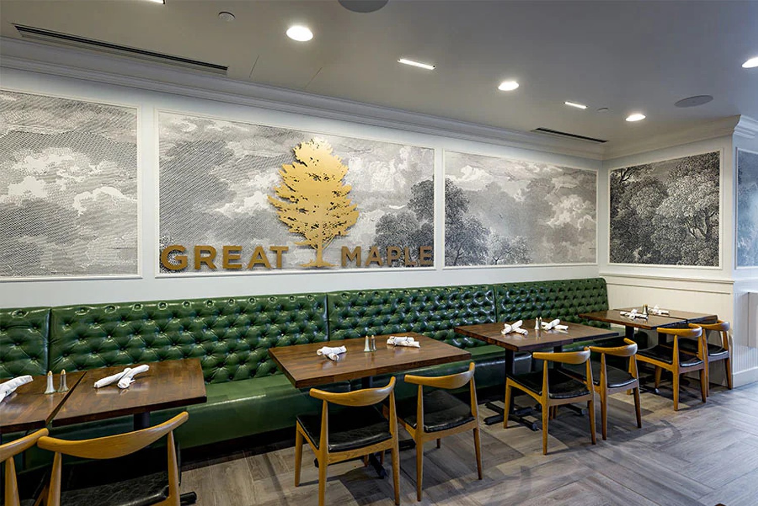 Tische im Great Maple Restaurant vor einem Wandbild der Nationalparks in Graustufen