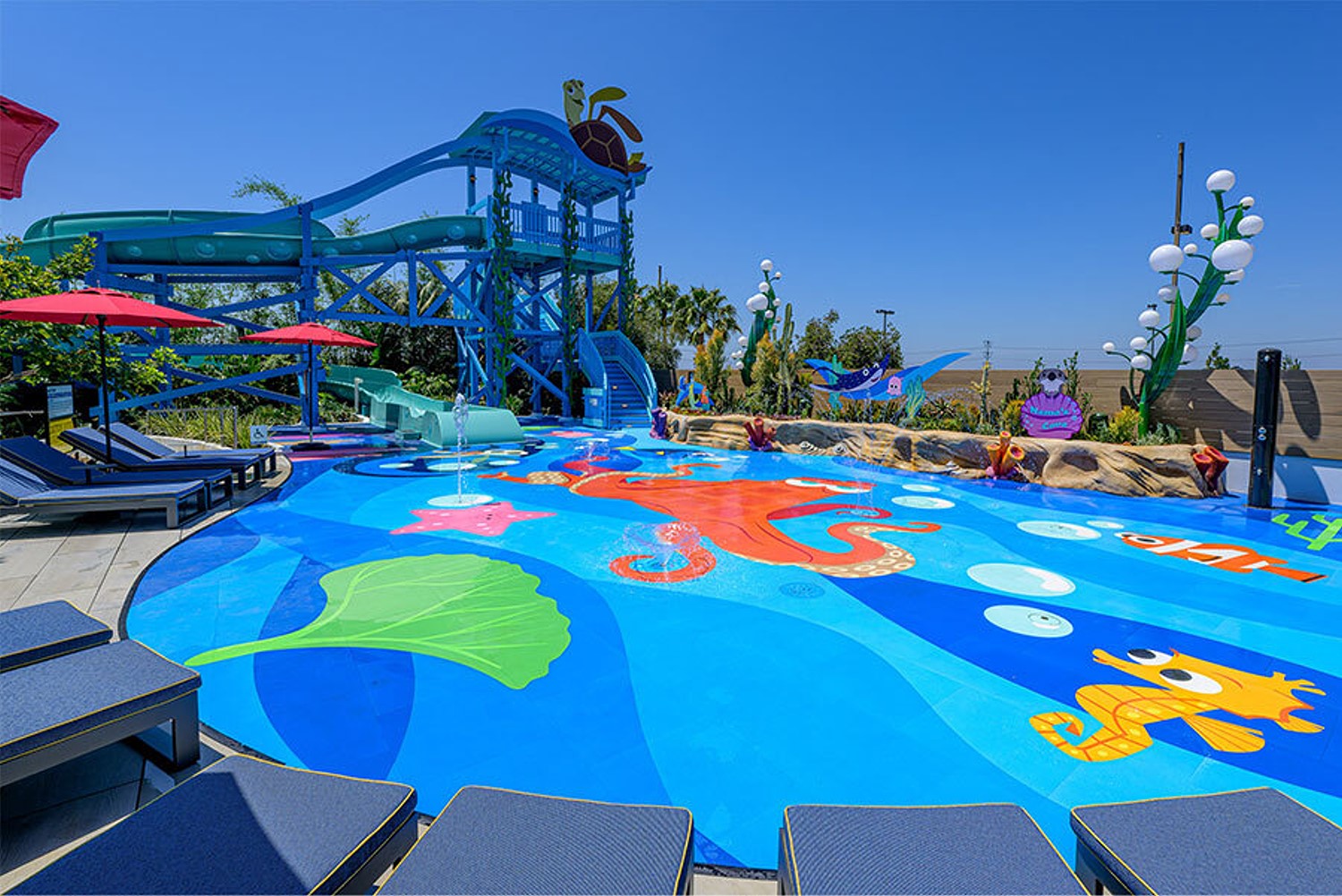 Poolbereich mit Splash Pad im Stil von Findet Nemo und einer Rutsche