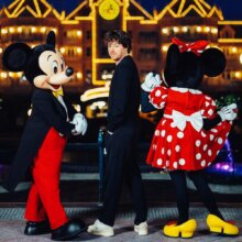 Jean Imbert posiert mit Mickey Mouse und Minnie Mouse vor dem Disneyland Hotel