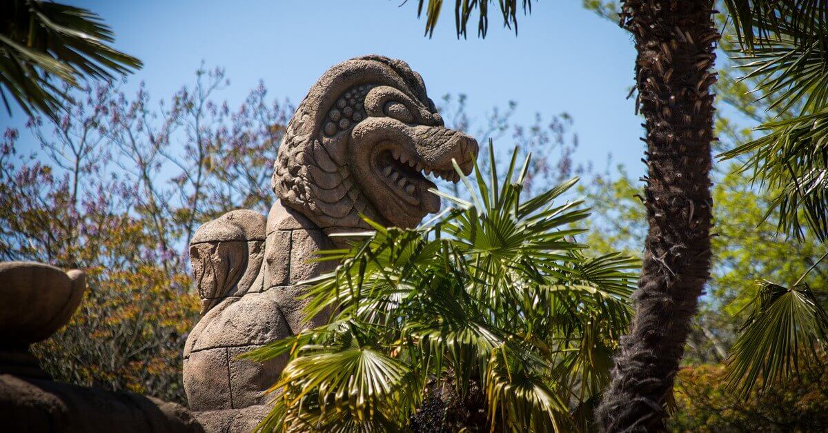 Achterbahnwagen hinter einer Löwenstatue bei Indiana Jones and the Temple of Peril